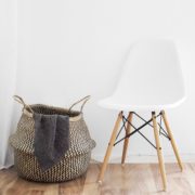 Silla blanca contra una pared blanca en un suelo de madera